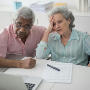 a man sitting beside a woman with hand on her head