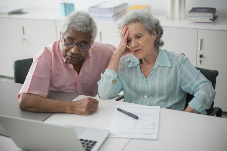 a man sitting beside a woman with hand on her head